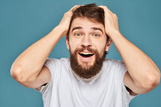 emotional man gesturing with hands lifestyle fun white t-shirt blue isolated stock. High quality photo