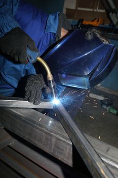 Welding. electric arc welding. The worker welding two iron corners.