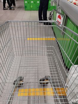 Social distance. Marking with yellow lines in a supermarket store to maintain distance under quarantine. Distance markings, signs on the floor in a drugstore, supermarket, shop at the checkout
