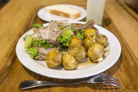 Hearty lunch. A plate with young potatoes and meat is standing on a tray with coffee and juice. Morning tomorrow. Refusal of a healthy lifestyle. Overeating gluttony.