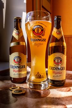 Erdinger beer is poured in a branded beer glass and two bottles of beer on the side. Erdinger beer on the table. 04.07.2015 Kiev Ukraine