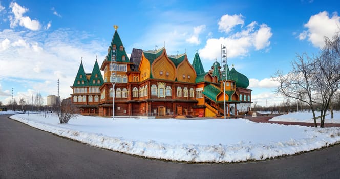 Wooden palace in Kolomenskoye. Winter landscape with snow on a background of blue sky with clouds in Kolomenskoye - a palace village, the former royal residence.