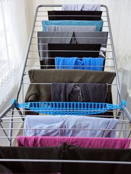 Drying clothes on the balcony in winter, drying clothes on the glass balcony, wet clothes are dried,