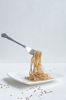 spaghetti made from buckwheat on a white table.