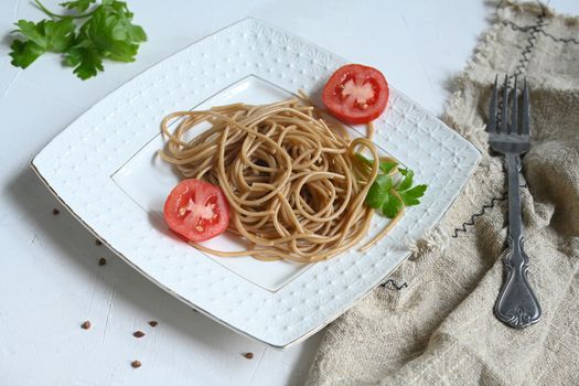 spaghetti made from buckwheat on a white table.