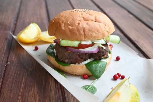 Milanese burger, with tomatoes, lettuce and french fries, in white background.