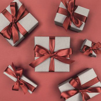 Gift boxes wrapped in craft paper with a brown ribbons and bows. Festive monochrome flat lay.