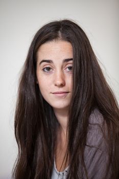 Portrait of a young and sweet natural woman without makeup with long brown hair