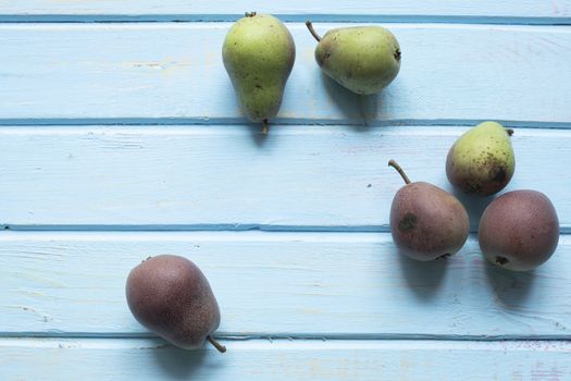 Halves of fresh ripe pears on wooden background.