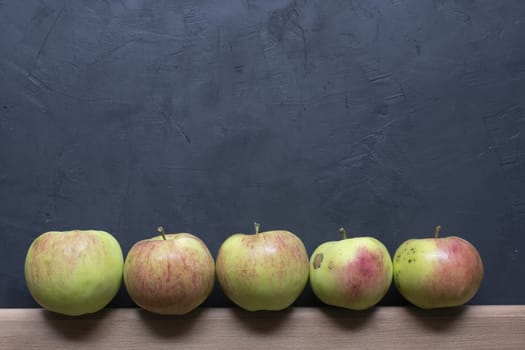 green and red apples on a black background.