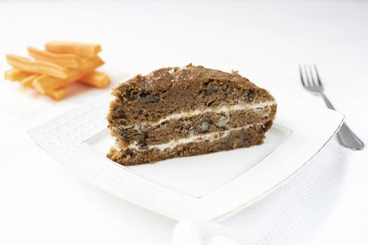 Slice of carrot cake and coffee on white background.