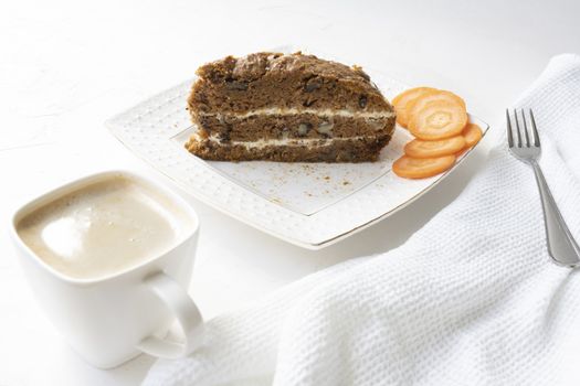 Slice of carrot cake and coffee on white background.