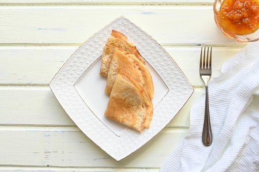 large pancakes with jam on white background