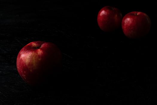 Red apple isolated on black wooden background