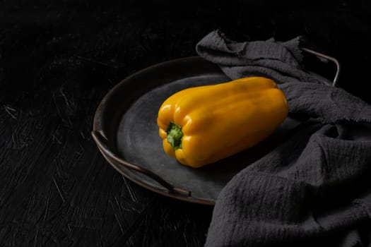 Image of yellow raw pepper on the black background