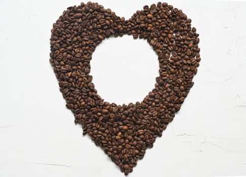 Heart made coffee beans on white background