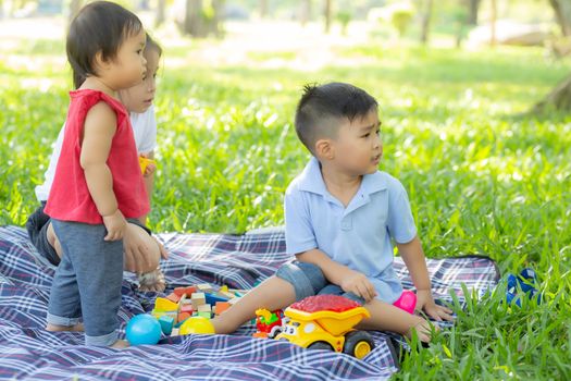Little boy and girl is playing for idea and inspiration with toy block, kid learning with construction block for education, child activity and game in the park with happy in the summer.
