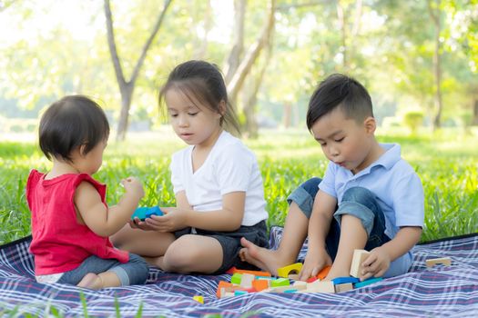 Little boy and girl is playing for idea and inspiration with toy block, kid learning with construction block for education, child activity and game in the park with happy in the summer.