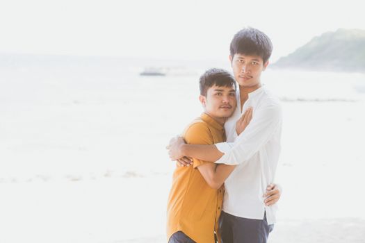 Homosexual portrait young asian couple standing hug together on beach in summer, asia gay going tourism for leisure and relax with romantic and happiness in vacation at sea, LGBT concept.