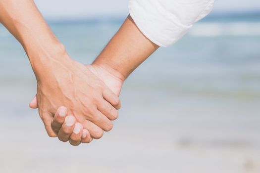 Closeup asian gay couple holding hands together on the beach with relax and leisure in summer, LGBT homosexual legal two man happy and romantic in vacation, relationship sex lover concept.