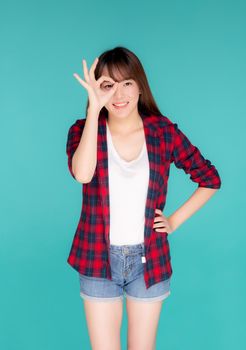 Beautiful happy young asian woman wear travel summer gesture ok sign with hand on eye having vision isolated on blue background, asia teenager girl expression with cheerful and fun while trip.