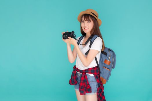 Beautiful young asian woman cheerful and enjoy travel trip summer isolated on blue background, asia girl having activity hobby take a photo holding camera, tourist journey in vacation and holiday.