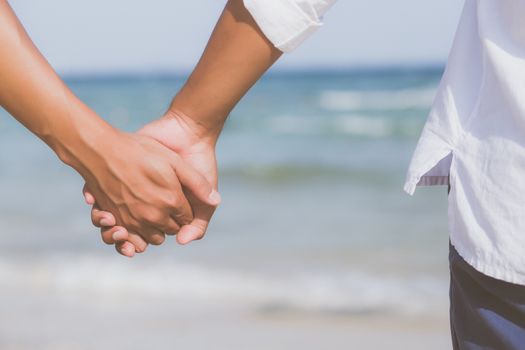 Closeup asian gay couple holding hands together on the beach with relax and leisure in summer, LGBT homosexual legal two man happy and romantic in vacation, relationship sex lover concept.