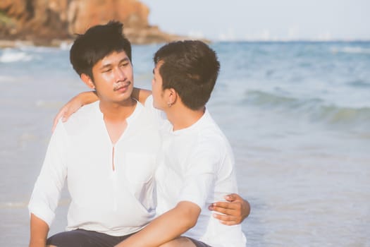 Homosexual portrait young asian couple sitting hug together on beach in summer, asia gay going tourism for leisure and relax with romantic and happiness in vacation at sea, LGBT legal concept.