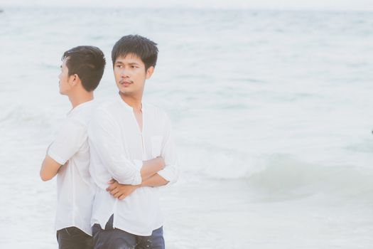 Homosexual portrait young asian couple standing problem on beach in summer, asia gay angry and unhappy in vacation at sea, relationship with disappointed and frustrated, LGBT with legal concept.