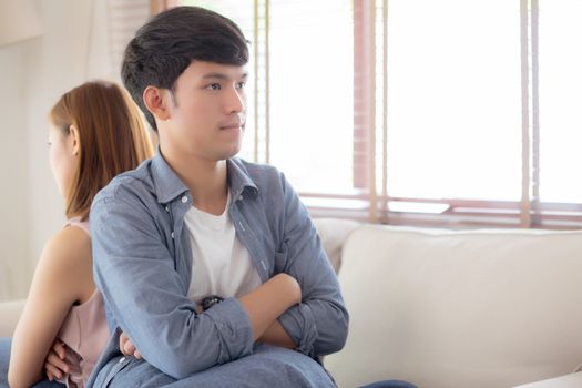 Relationship of young asian couple having problem on sofa in the living room at home, family having conflict argument with unhappy, man and woman with issue, failure and stress together.