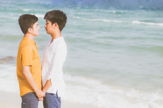 Homosexual portrait young asian couple standing together on beach in summer, asia gay holding hands going sea for leisure and relax with romantic and happy in vacation at sea, LGBT with legal concept.