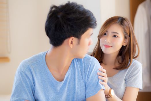 Young asian couple a problem and woman ask forgive and sorry with man feeling angry at bedroom, asia wife excuse convince husband with relationship, family and lifestyle concept.