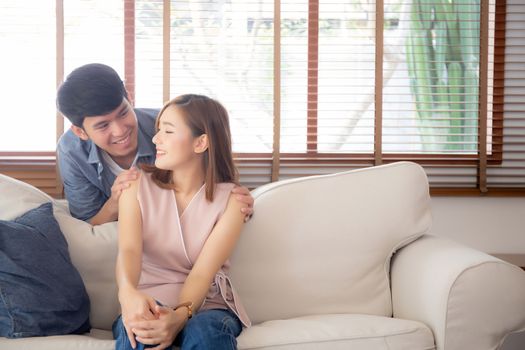 Beautiful portrait young asian couple relax and satisfied together in living room at home, family sitting couch confident with cheerful and happy with relationship, man and woman dating.