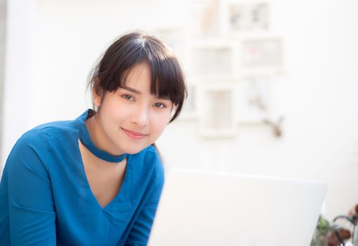 Beautiful portrait asia young woman working online on laptop sitting at cafe shop, professional female freelance using notebook computer, business and communication concept.