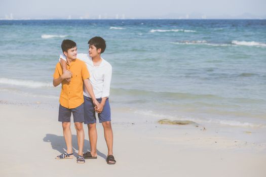 Homosexual portrait young asian couple standing hug together on beach in summer, asia gay going tourism for leisure and relax with romantic and happiness in vacation at sea, LGBT concept.