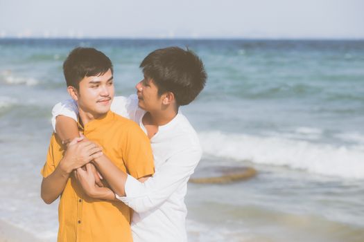 Homosexual portrait young asian couple standing hug together on beach in summer, asia gay going tourism for leisure and relax with romantic and happiness in vacation at sea, LGBT concept.