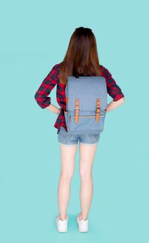 Back view of beautiful young asian woman travel with backpack isolated on blue background, rear asia girl is student or tourist in vacation in summer trip, holiday and traveller concept.