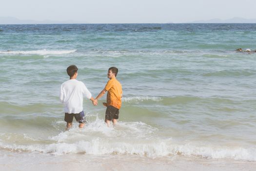 Homosexual portrait young asian couple running with cheerful together on beach in summer, asia gay going tourism for leisure and relax with happiness in vacation at sea, LGBT legal concept.