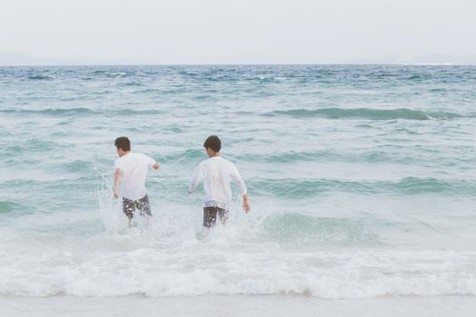 Homosexual portrait young asian couple running with cheerful together on beach in summer, asia gay going tourism for leisure and relax with happiness in vacation at sea, LGBT legal concept.