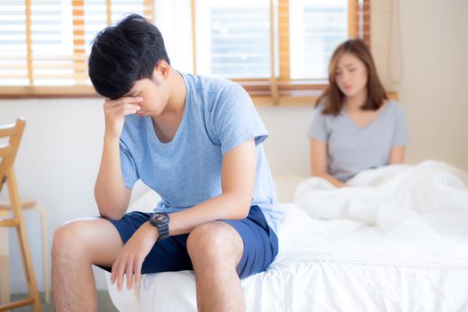 Asian young couple having problem of man worried impotent and unhappy at bedroom, trouble divorce of family with frustrated, husband having depression, conflict of love concept.