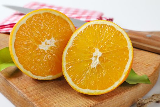 Two fresh orange halves on cutting board