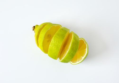 Lemon with green peel and yellow flesh, sliced