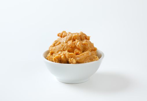 Crunchy peanut butter in white bowl