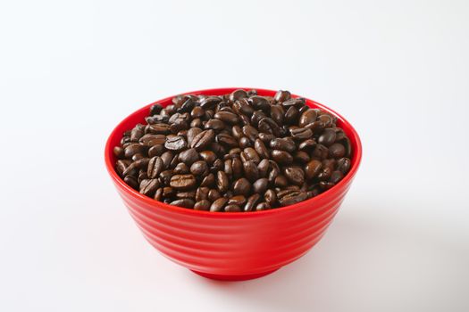 Roasted coffee beans in red bowl