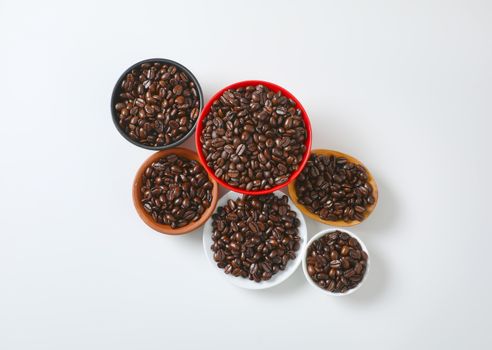 Roasted coffee beans in various bowls and on plate