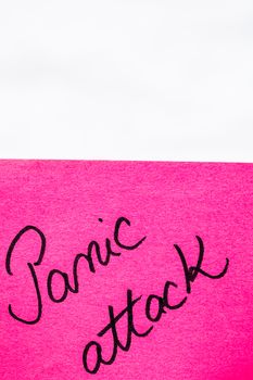 Panic attack handwriting text close up isolated on pink paper with copy space. Writing text on memo post reminder