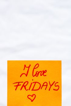 I love fridays handwriting text close up isolated on orange paper with copy space.