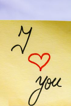 I love you handwriting text close up isolated on yellow paper with copy space.