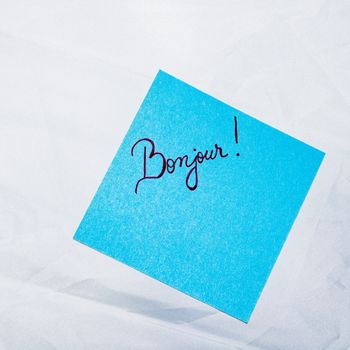 Text Bonjour on post it. Writing on colorful sticky note. Bucharest, Romania, 2020.