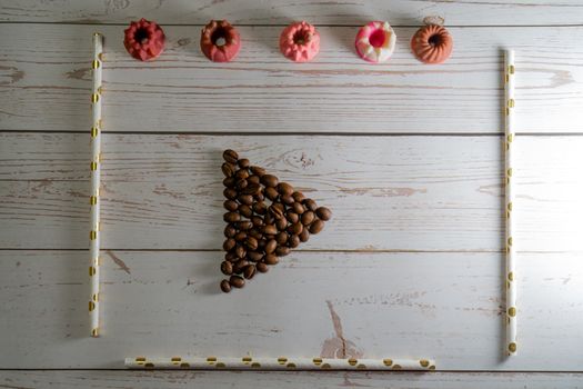 flatlay concept abstract showing coffee beans, straws, candies candles on a white wooden background perfect for a cafe menu or restaurant with copyspace. Shows the elegance of a bakery making winter drinks for christmas, thanksgiving and just spring